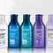 A row of 8 different colored bottles of Redken shampoos for all hair types against a white background.