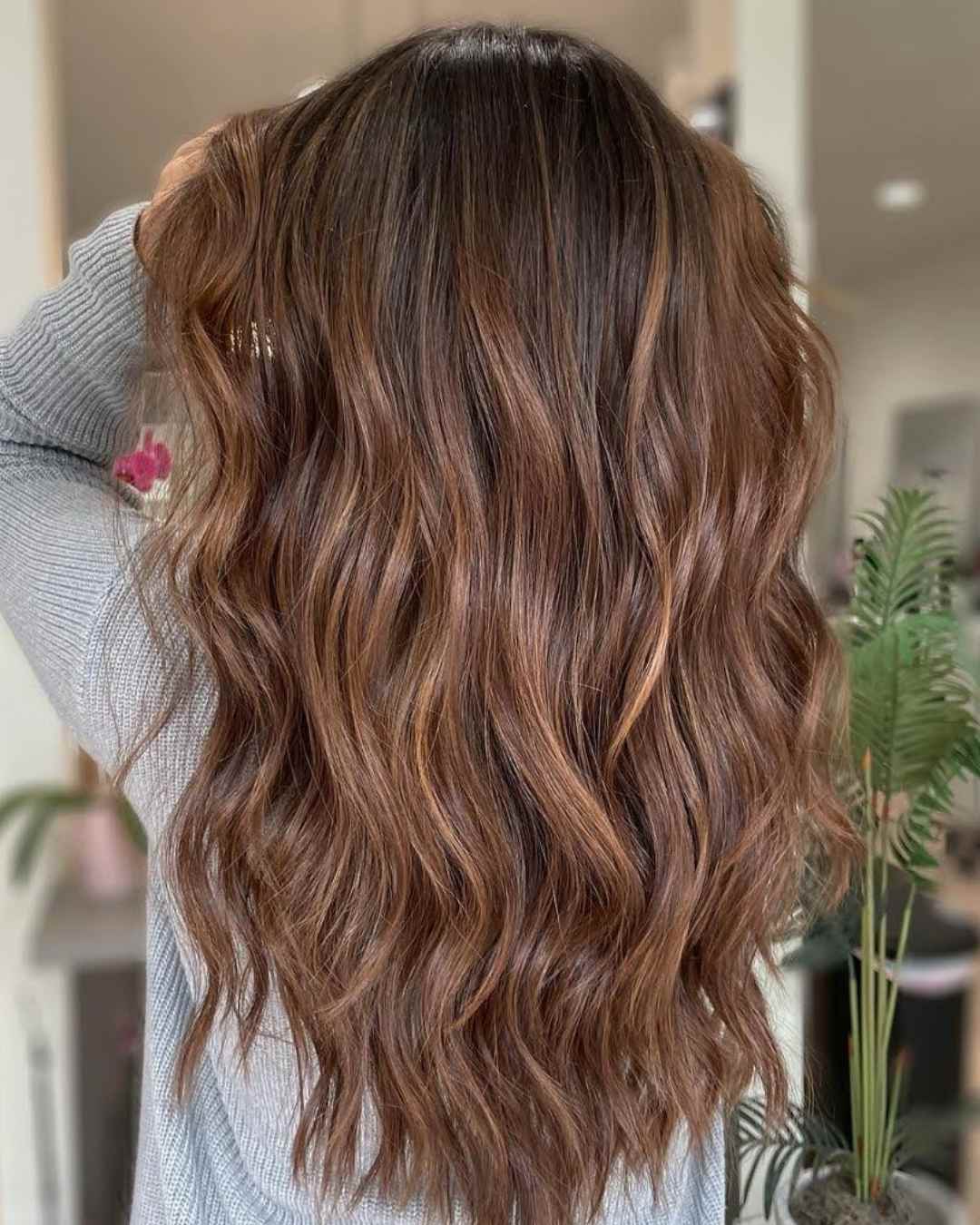 A hand holding a section of blonde hair