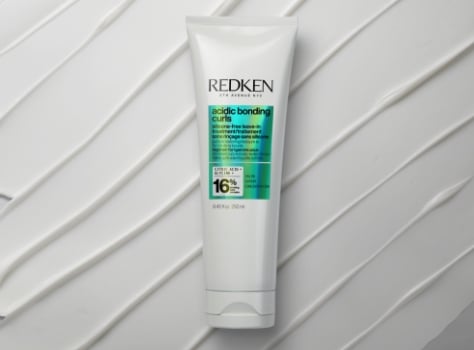 A bottle of Redken Acidic Bonding Concentrate leave-in treatment on a white background.