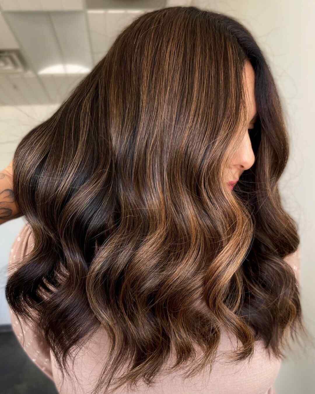 Long, wavy, brown hair with caramel balayage highlights