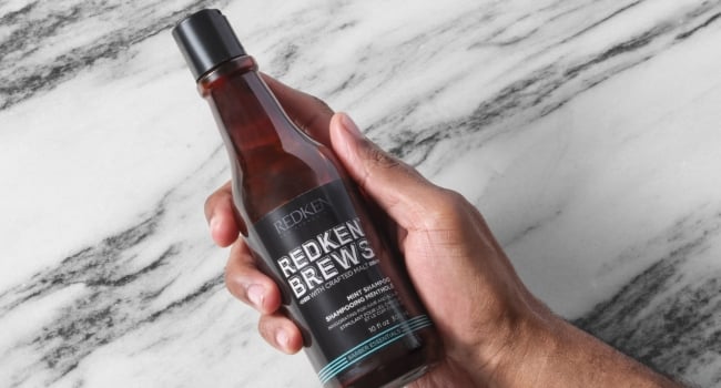Discover Redken Brews Mint Shampoo in hand
