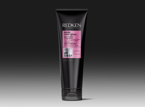 A tube of Redken Acidic Color Gloss Gloss-in-Mask on a dark background.