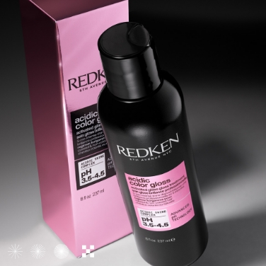 A bottle of Redken's Acidic Color Gloss sits in front of its box.